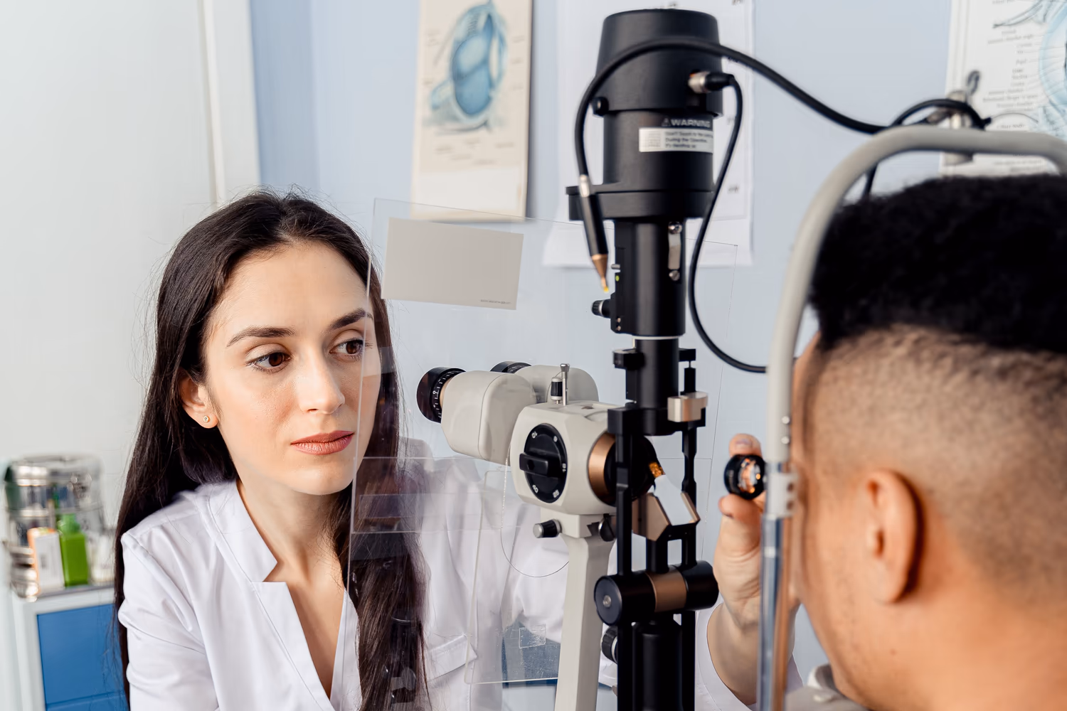 Profissional de saúde ocular examina paciente na lâmpada de fenda