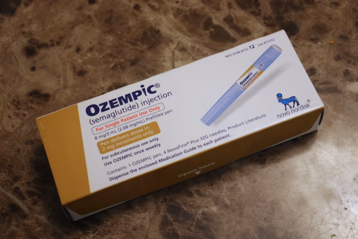 Caixa de Ozempic e caneta injetora de semaglutida sobre superfície neutra